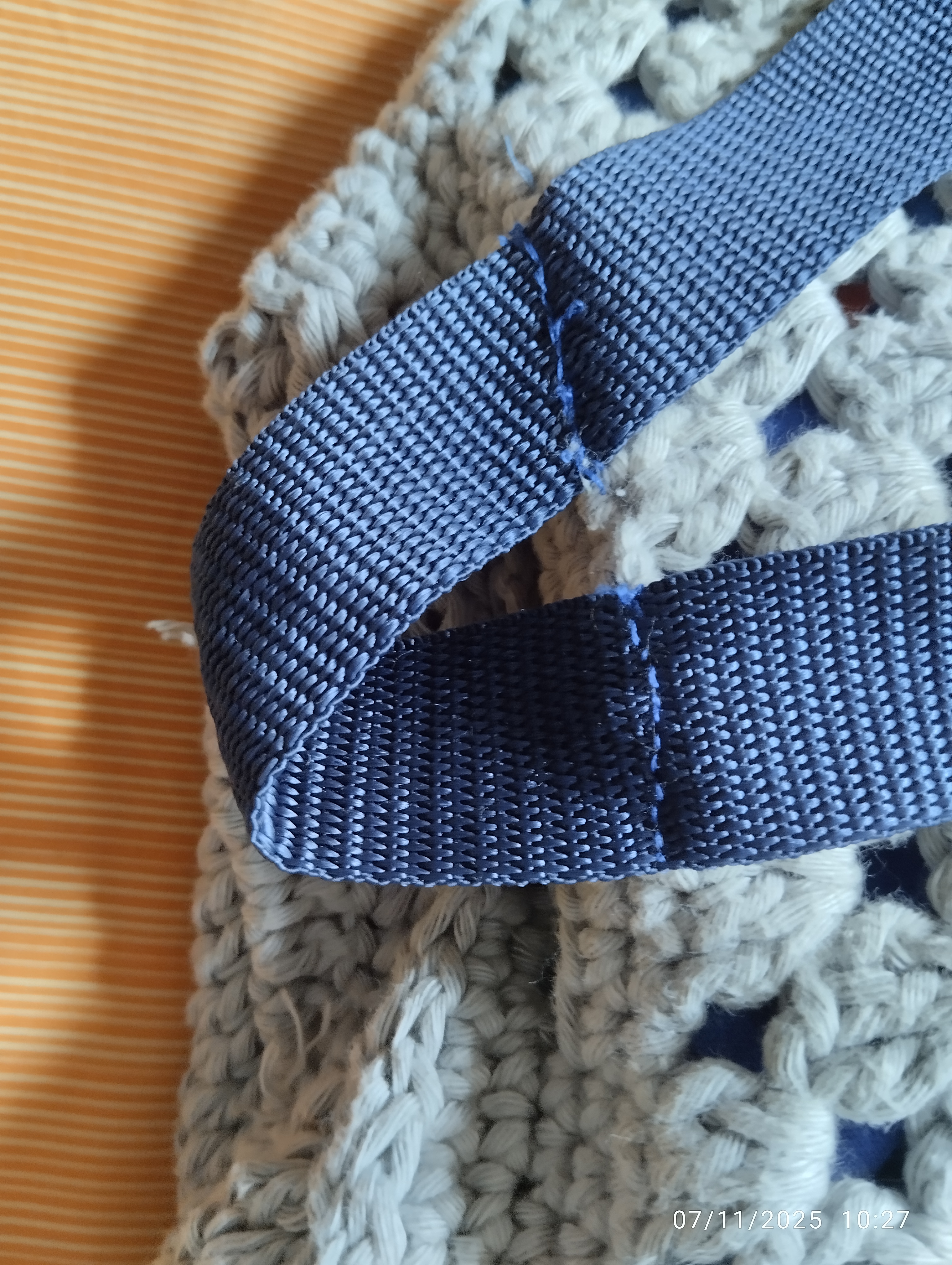 closeup to handsewn straps to bag to create a loop